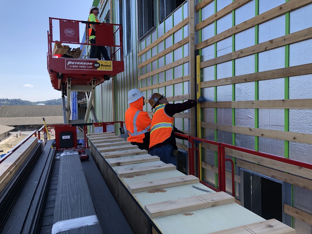 Workers on a commercial job site installing Yakisugi "shou sugi ban"